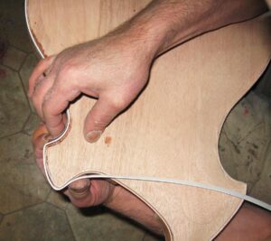 Biding being applied to the back of the guitar body