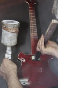 Applying the final clear coat to the guitar